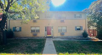 Louisville apartment for rent - a yellow brick building with a red door and a sidewalk in front of it