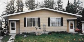 Rocky Mountain House apartment for rent - A small house with a white door and a window with a white curtain.