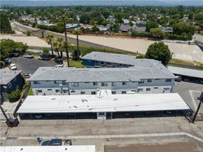 Winnetka apartment for rent - A large building with a grey roof is surrounded by a parking lot and other buildings.