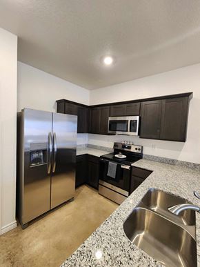 Copperas Cove apartment for rent - A kitchen with a stainless steel refrigerator, microwave, and oven.