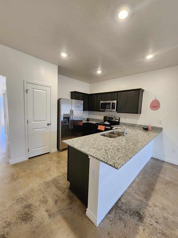 Copperas Cove apartment for rent - A kitchen with a granite countertop and black cabinets.