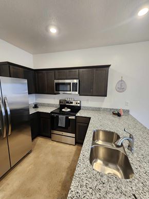 Copperas Cove apartment for rent - A kitchen with a stainless steel refrigerator, microwave, oven, and sink.