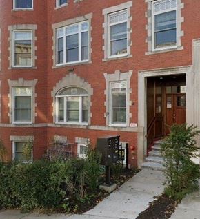 Brighton apartment for rent - A red brick building with a black mailbox and a brown door.