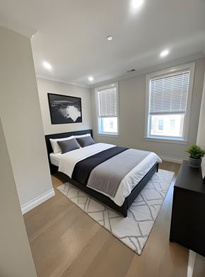 Brighton apartment for rent - A bedroom with a large bed and a small plant on the desk.