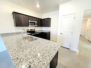 Copperas Cove house for rent - a kitchen with granite counter tops and a sink