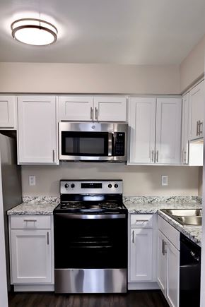 Dewitt apartment for rent - A kitchen with white cabinets and a black stove top oven.