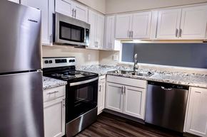Dewitt apartment for rent - A kitchen with white cabinets and stainless steel appliances.