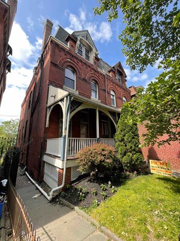 Philadelphia apartment for rent - A red brick building with a balcony and a sign that says "RENT".