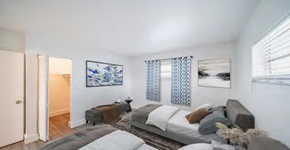 Davie apartment for rent - A bedroom with a large bed and a painting on the wall.