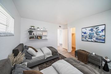 Davie apartment for rent - A living room with a grey couch and a large painting on the wall.