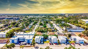 Davie apartment for rent - A sunset view of a cityscape with buildings and palm trees.