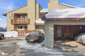 Anchorage apartment for rent - A car is parked in a driveway with snow on the ground.