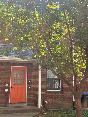 Washington apartment for rent - a red door on a brick house with a tree