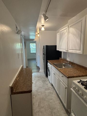 Washington apartment for rent - a kitchen with white cabinets and granite counter tops
