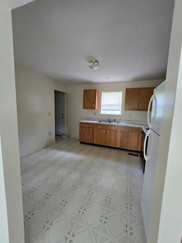 West Liberty house for rent - A kitchen with a washing machine and a refrigerator.