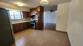 Killeen house for rent - an empty kitchen with wooden cabinets and a ceiling fan