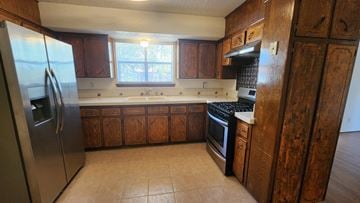 Killeen house for rent - a kitchen with wooden cabinets and stainless steel appliances