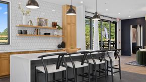 Mcdonough apartment for rent - A kitchen with a white counter and black chairs.