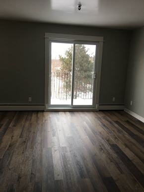 Kentville apartment for rent - an empty living room with a door to a balcony