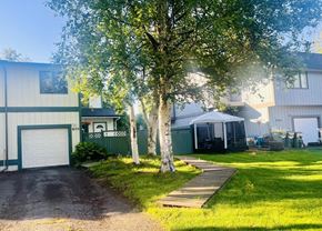 Anchorage house for rent - a house with a yard and a tree in front of it