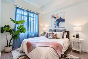 Salt Lake City apartment for rent - A bedroom with a large bed and a potted plant.