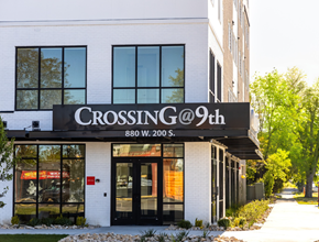 Salt Lake City apartment for rent - A white building with a black awning that says "Crossing @ 9th".