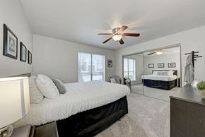 Austin apartment for rent - A bedroom with a large bed and a ceiling fan.
