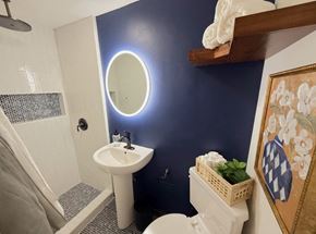 Merced house for rent - a bathroom with a blue wall and a white toilet and sink