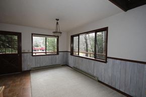 Whitefish apartment for rent - A room with a white ceiling and a window with a view of trees and a red car.