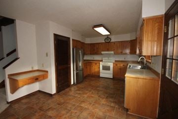 Whitefish apartment for rent - A kitchen with brown tile floors and wooden cabinets.