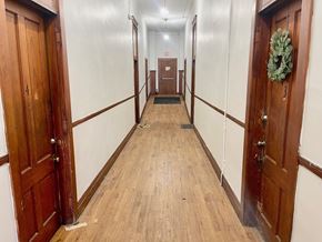 Louisville apartment for rent - A long hallway with doors on both sides and a wreath on the right door.
