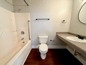 Louisville apartment for rent - A white toilet sits in a bathroom next to a bathtub and sink.