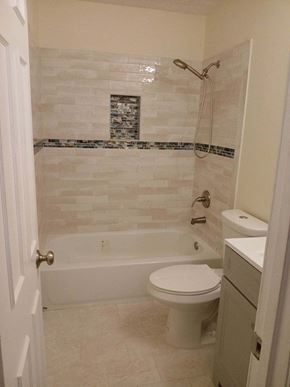 Bowie house for rent - A white toilet sits next to a bathtub in a bathroom.