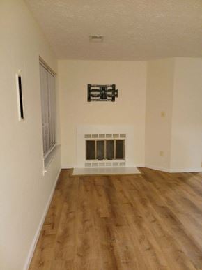 Bowie house for rent - A room with a fireplace and wood flooring.