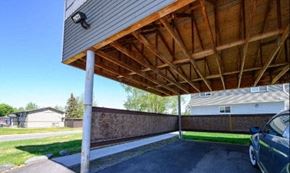 Anchorage apartment for rent - a car parked under a covered porch on a house