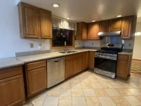 Anchorage house for rent - A kitchen with wooden cabinets and a black oven.