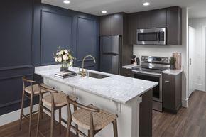 Portland apartment for rent - A kitchen with dark blue cabinets and a white marble countertop at The Fitz Apartments, Oregon