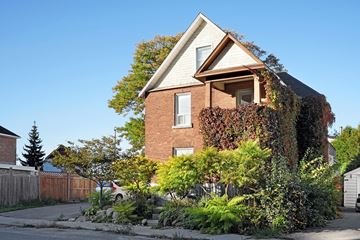 Ottawa apartment for rent - A house with a red brick exterior and a white window.