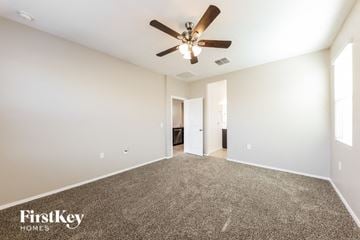Surprise house for rent - a living room with carpet and a ceiling fan