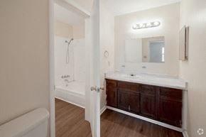 Russellville apartment for rent - A bathroom with a white tub and wooden floors.