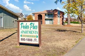 Russellville apartment for rent - A sign for Parker Place Apartments is in front of a building.