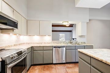 Slidell house for rent - A kitchen with a stove top oven and a dishwasher.