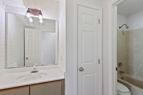 Slidell house for rent - A white bathroom with a sink, mirror, toilet and shower.