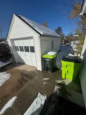 Colorado Springs house for rent - the side of a garage with three trash cans on the driveway