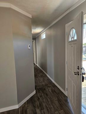 Guthrie house for rent - A hallway with a white door and a light switch on the wall.