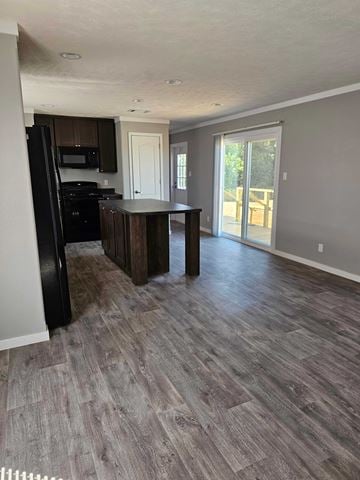 Guthrie house for rent - A kitchen with a black refrigerator and wooden cabinets.