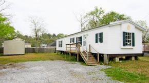 Slidell house for rent - A white house with green shutters and a porch.