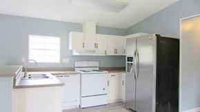 Slidell house for rent - A kitchen with white appliances and cabinets.