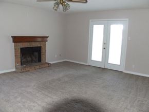 Slidell house for rent - A room with a fireplace and a ceiling fan.
