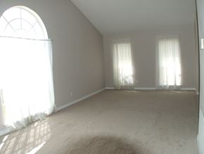 Slidell house for rent - A sunny room with a carpet and two windows.